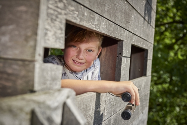 Jongen met verrekijker in uitkijktoren Resterheide